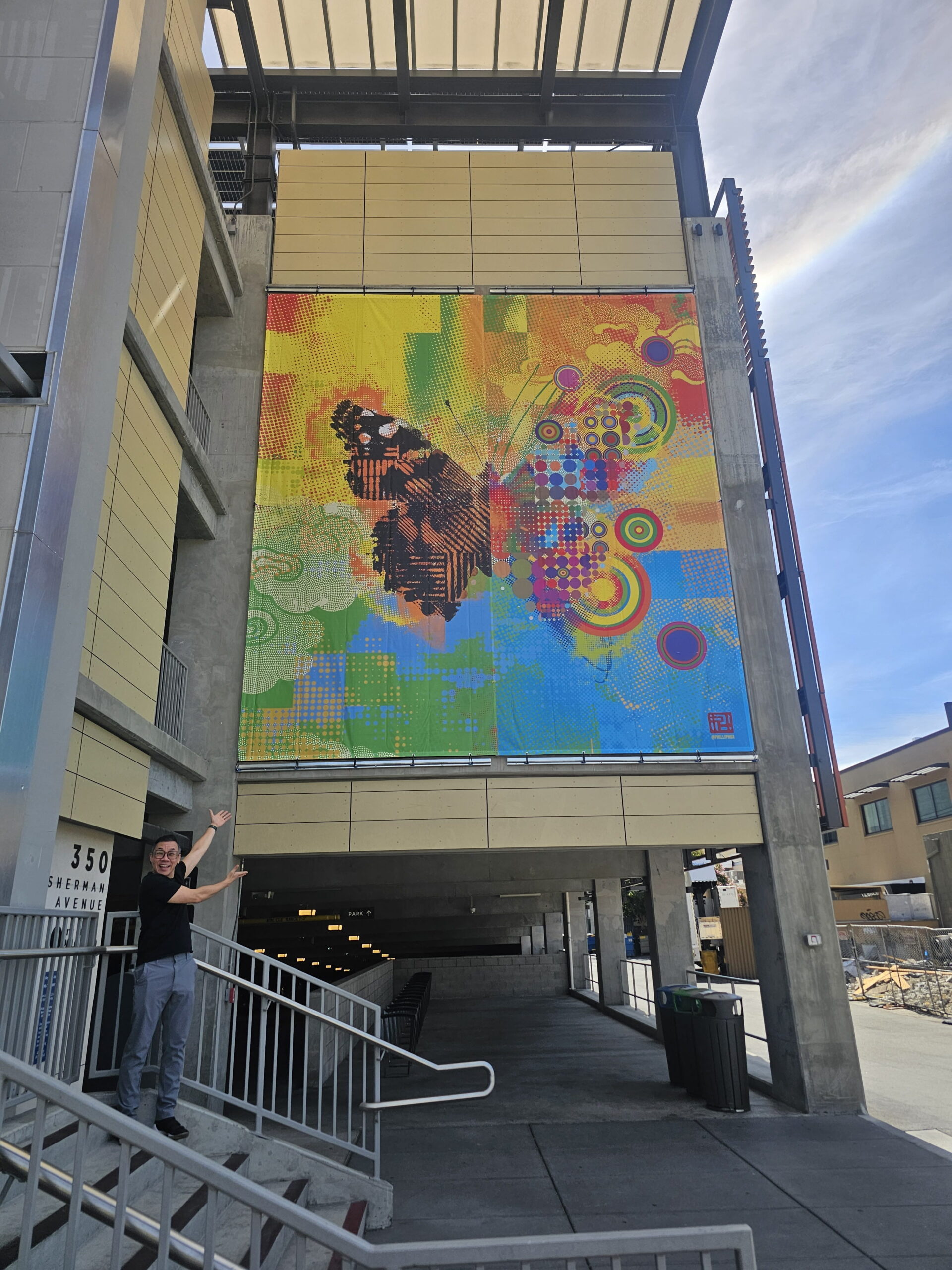 Large colorful butterfly mural banner on building facade in San Jose, CA