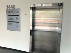 Lobby directory signs beside an elevator at 1440 O'Brien Drive
