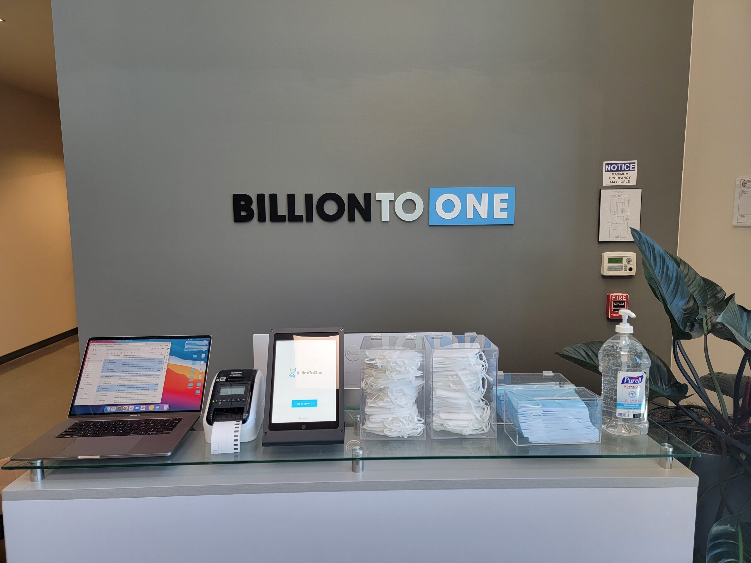 A modern lobby sign for Billion to One with dimensional letters and a blue panel